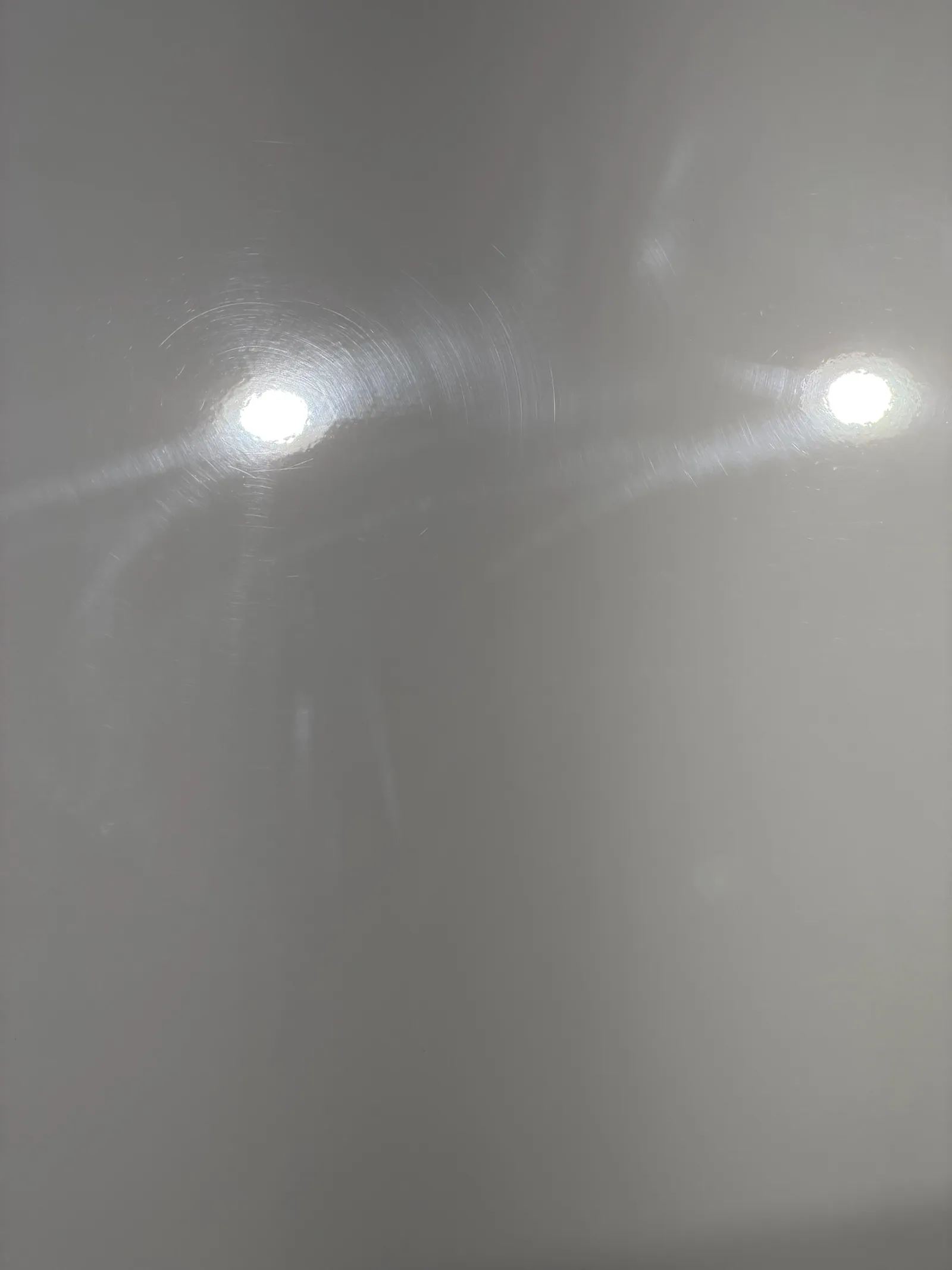 Before: close-up of white Silverado door paint under inspection lights
