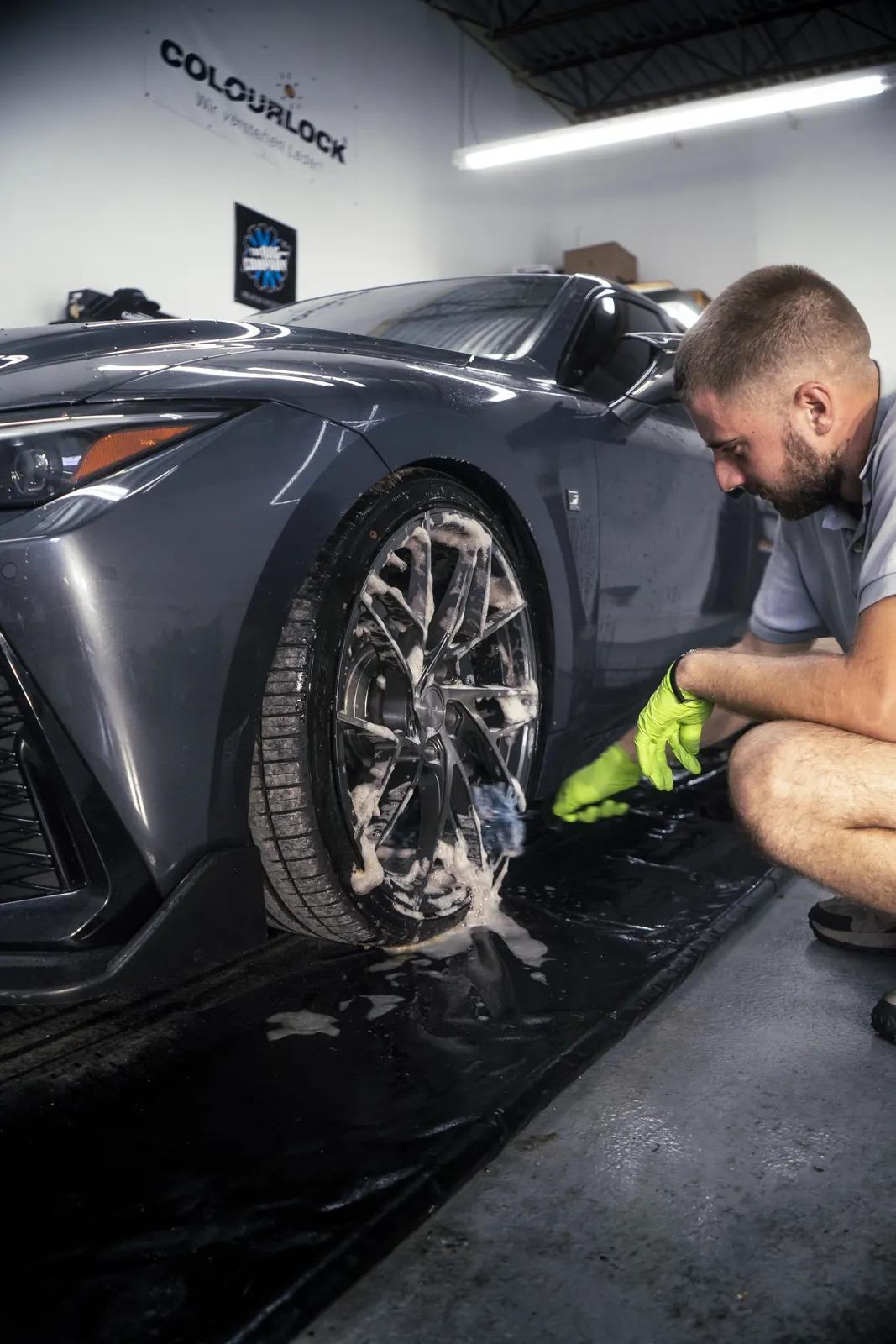 Wheel and tire scrubbed by hand on a grey Lexus IS